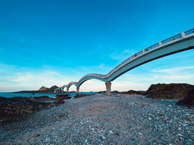 Bridge over water against blue sky