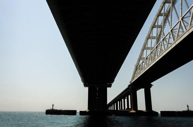 A bridge over the water with the water in the foreground.