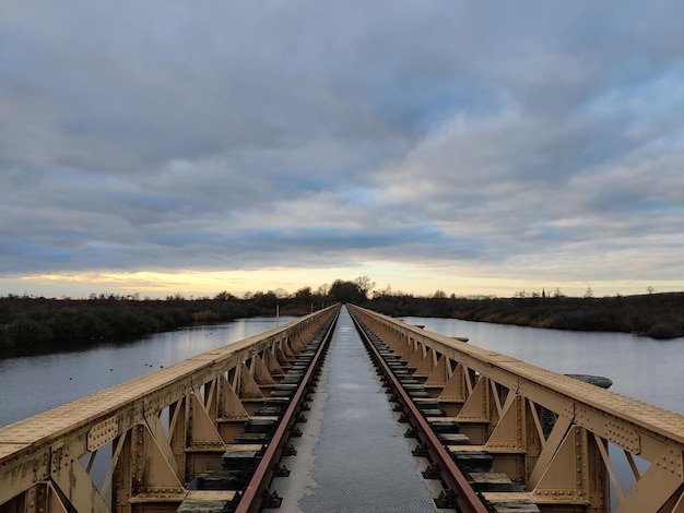 Photo bridge with rails above a lake sky