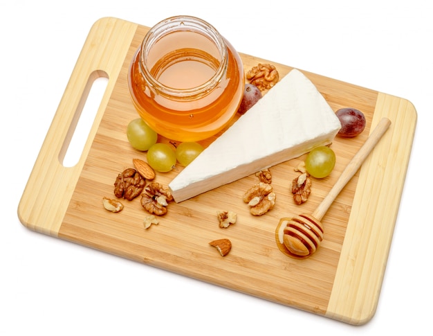 Сыр бри или камамбер и мед на белом фоне