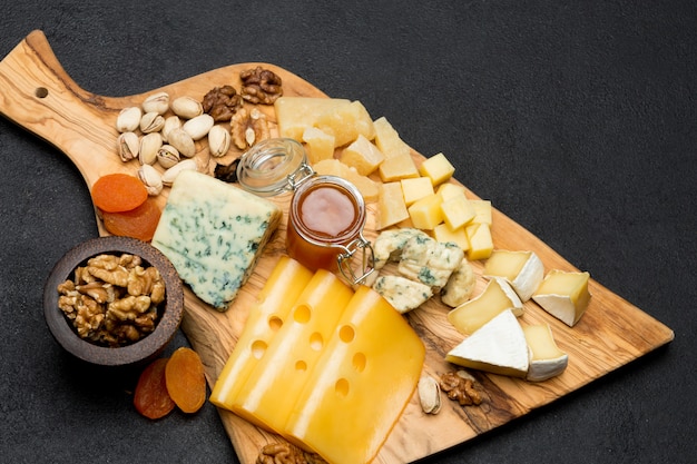 brie, camembert, roquefort and cheddar on wooden board