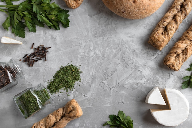 brie cheese with fersh bread and parsley on the grey background.