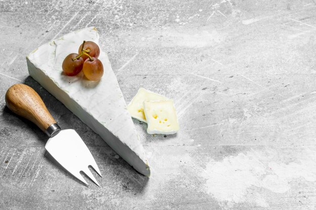 Brie cheese with grapes and knife