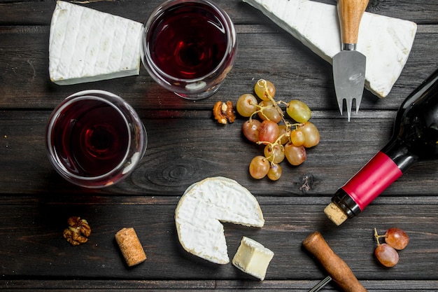 Photo brie cheese with red wine nuts and grapes