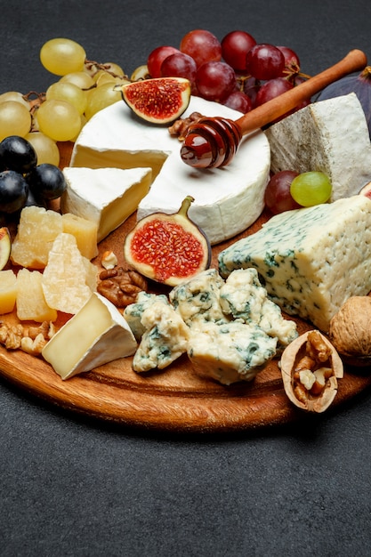 Brie cheese on a wooden Board with fresh figs and grapes