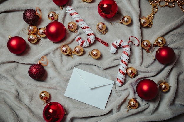 Brief aan de kerstman. Plat met rode kerstballen, gouden kerstballen en kerststokken op de plaid.