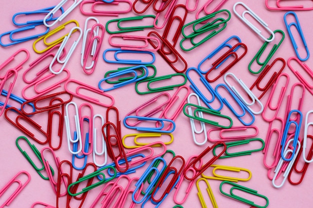 Briefpapier gekleurde paperclips opgemaakt op een roze achtergrond