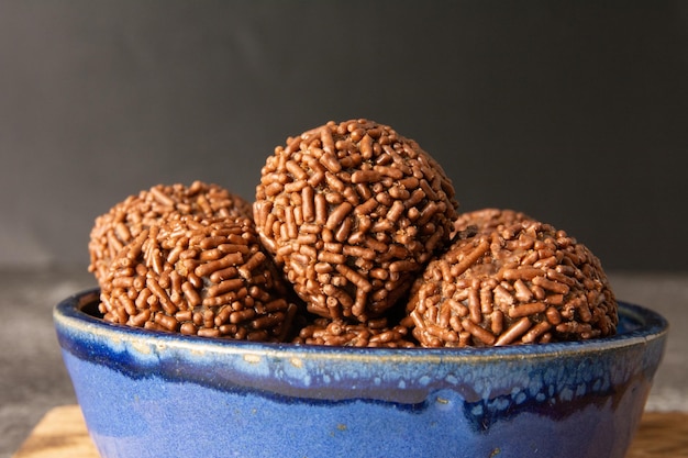 Foto brigadeiro palle di cioccolato brasiliane caramelle da festa con fiocchi di cioccolate vista anteriore sfondo scuro