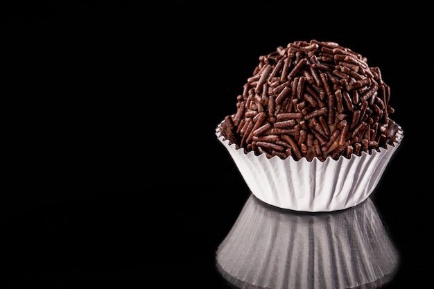 Brigadeiro a brazilian sweet, on a black background.