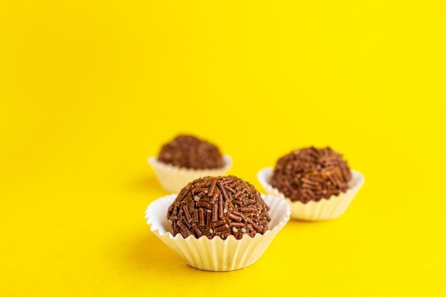 Brigadeiros on yellow background.