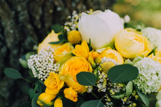 Фото Яркий и красочный осенний свадебный букет с желтыми розами, белым пионом.