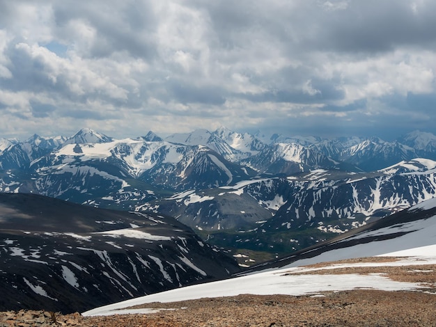 Bright atmospheric scenery on top of mountain ridge above clouds in thick low clouds Beautiful landscape with spotted mountain range with sunlight under dense clouds