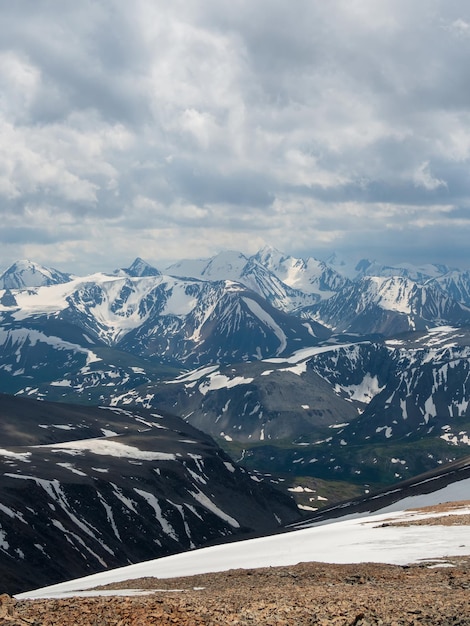 Bright atmospheric scenery on top of mountain ridge above clouds in thick low clouds Beautiful landscape with spotted mountain range with sunlight under dense clouds