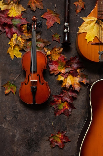 Bright autumn maple leaves mandolin violin flute and guitar The concept of autumn musical and artistic events