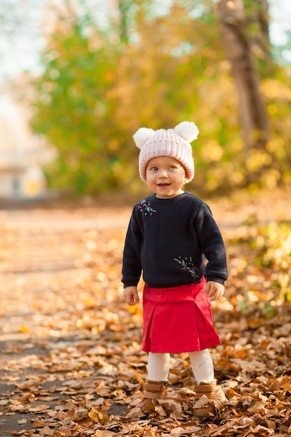 Bright autumn portrait of a cute baby on a walk. Orange. High quality photo