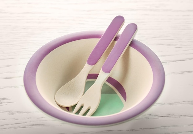 Bright baby tableware on wooden table