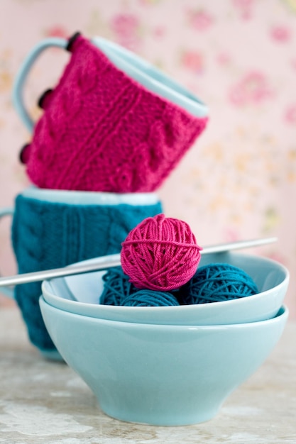 Bright balls of yarn in blue plates and handmade from felt heart