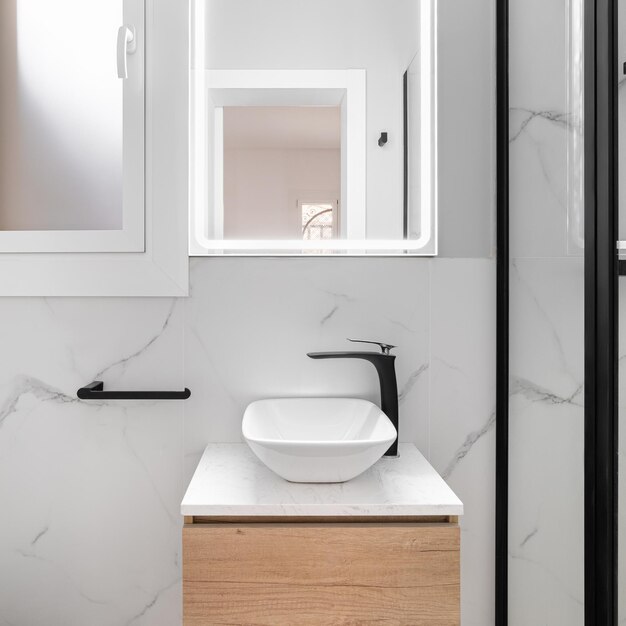 Bright bathroom boasts a sleek and minimalist style featuring a gleaming white sink set against a