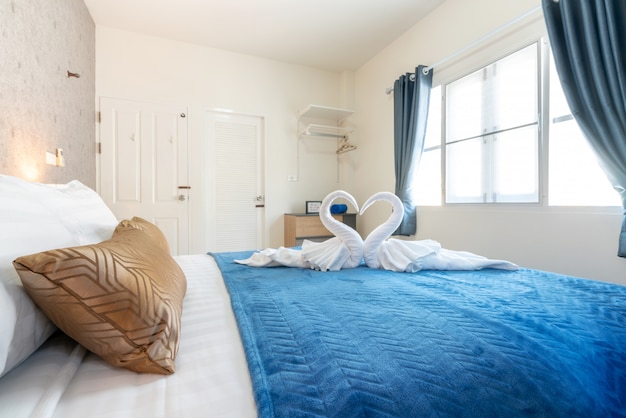 ベッドの上の白鳥のタオルで家の明るい寝室