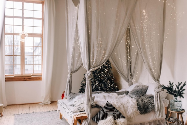 Bright bedroom with Christmas decor and a Christmas tree