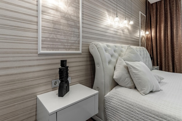 대형 흰색 침대와 카피톤 헤드보드가 있는 밝은 침실