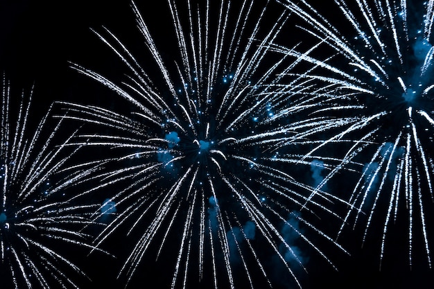 Bright blue fireworks in the night sky. New Year celebration