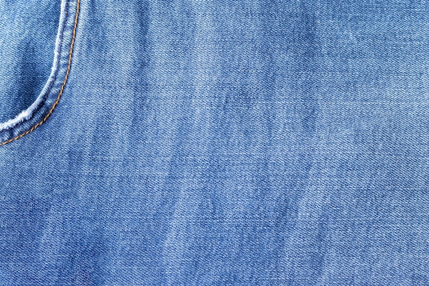 Trama del tessuto jeans blu brillante. fondo in denim con tasca nell'angolo