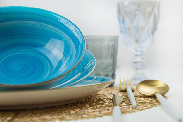 Bright blue serving plates with a spiral pattern tilted one after the other serving devices of gold