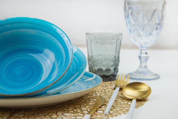 Bright blue serving plates with a spiral pattern tilted one after the other serving devices of gold
