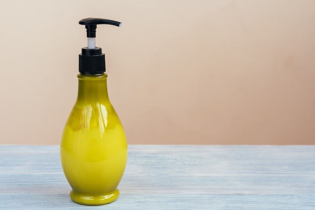 Bright bottle with cosmetic cream stands on the table