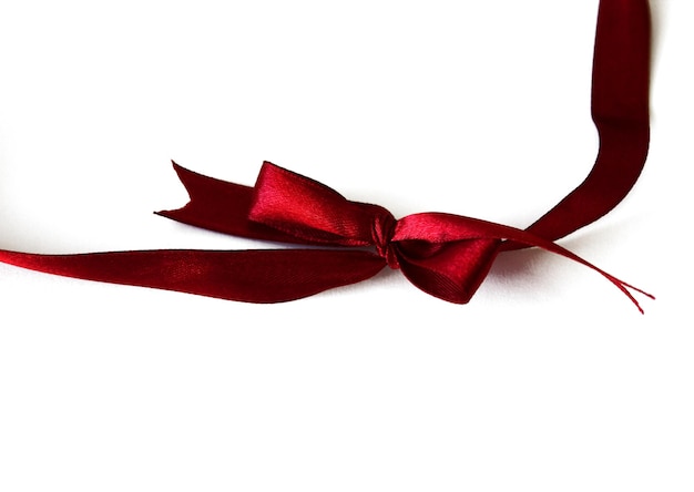 Bright burgundy silk ribbon bow isolated on white background