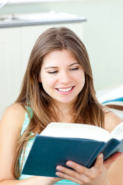 Bright caucasian woman reading a book at home