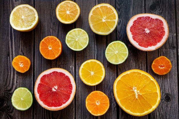 Bright citrus fruits on a wooden dark background