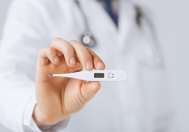 bright close up of male doctor with thermometer