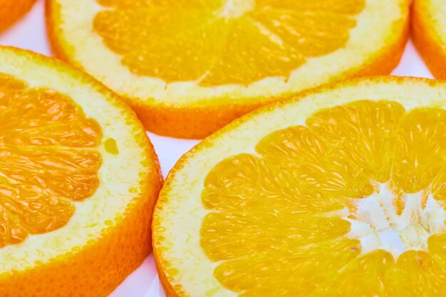 Bright close up three of orange slices with fleshy center and white background