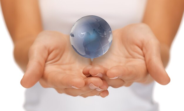 Immagine luminosa del primo piano delle mani della donna che tengono il globo terrestre