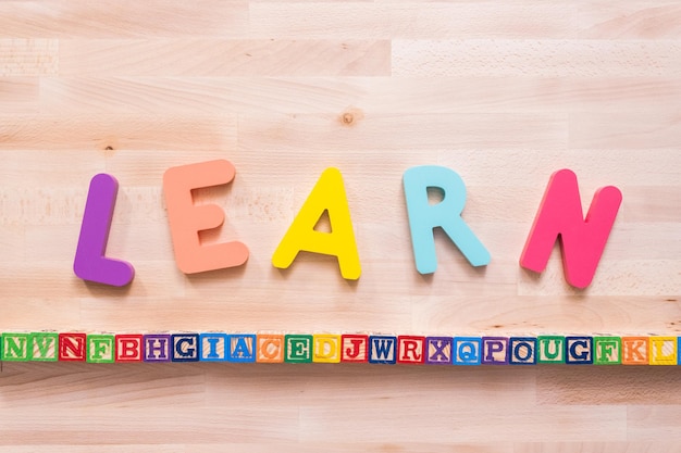 Bright color wooden LEARN sign on wood desk.