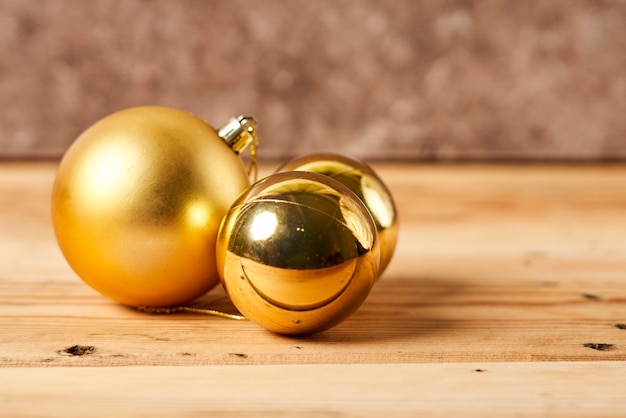 Bright and colorful christmas tree baubles on wooden board over decorated xmas tree