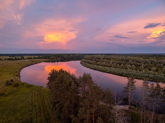 Nuvole colorate luminose sul fiume dopo il tramonto