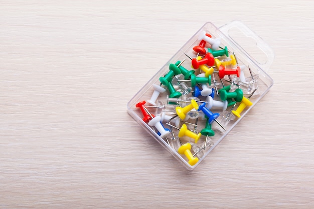 Bright colorful push pins on wooden table