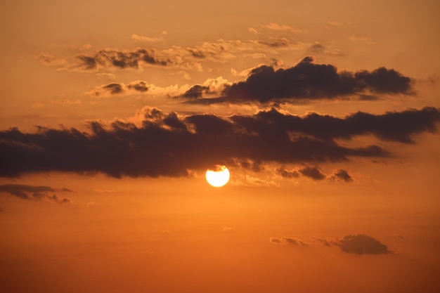 Bright colorful sunset sky with rays of setting sun and vivid dark clouds