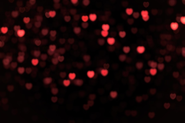 Bright and dark red little hearts blur bokeh on black background. Design element for overlay.