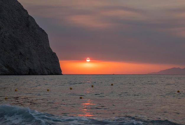 Bright dawn on the black beach of Santorini Perissa