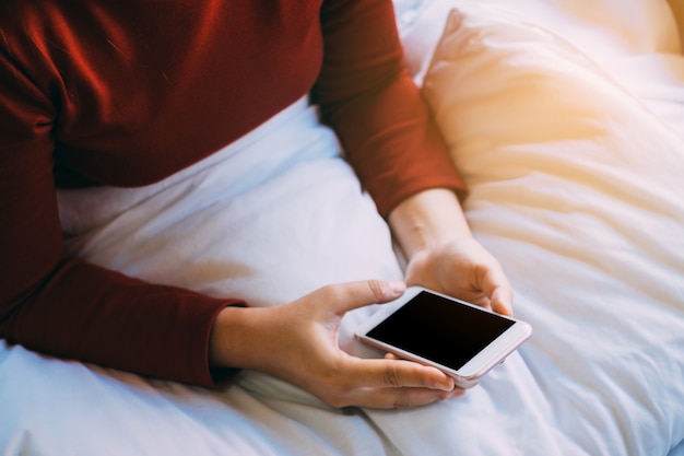 Foto una giornata luminosa di una giovane donna che utilizza smartphone