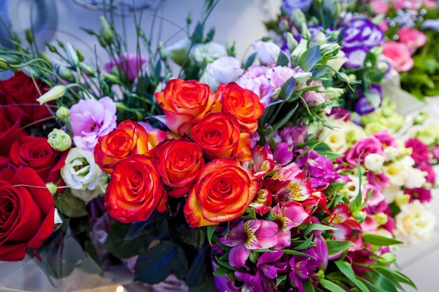 Bright decorations of flowers on the table at a wedding ceremony A group of colorful red