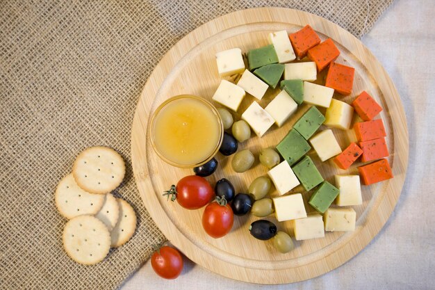 Formaggio diverso brillante primo piano di formaggio olandese rosso e verde brillante su una tavola di legno isolata su uno sfondo bianco