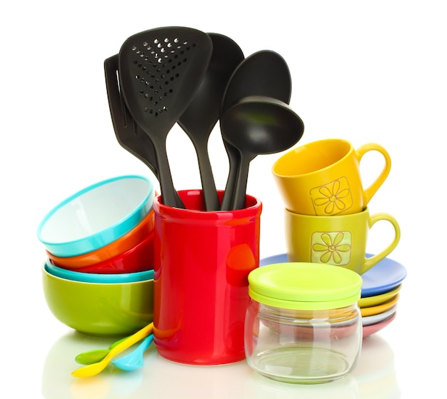 Bright empty bowls cups and kitchen utensils isolated on white