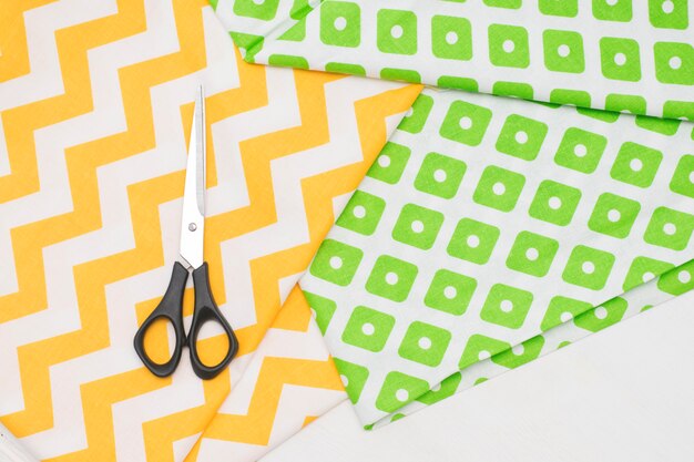 Bright fashionable fabric with a pattern for sewing and scissors top view