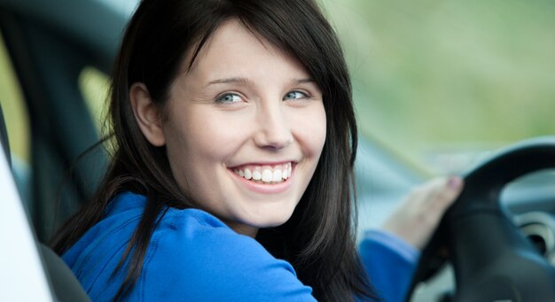 Autista femminile brillante che si siede in un'automobile