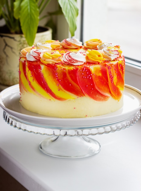 Bright festive cake with roses on the windowsill